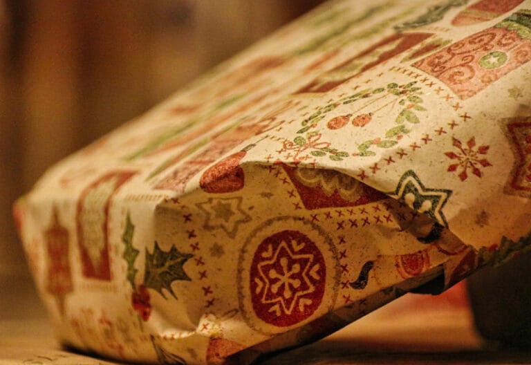 Verpakt cadeau met kerstachtig inpakpapier als suggestie voor cadeau voor iemand die alles al heeft