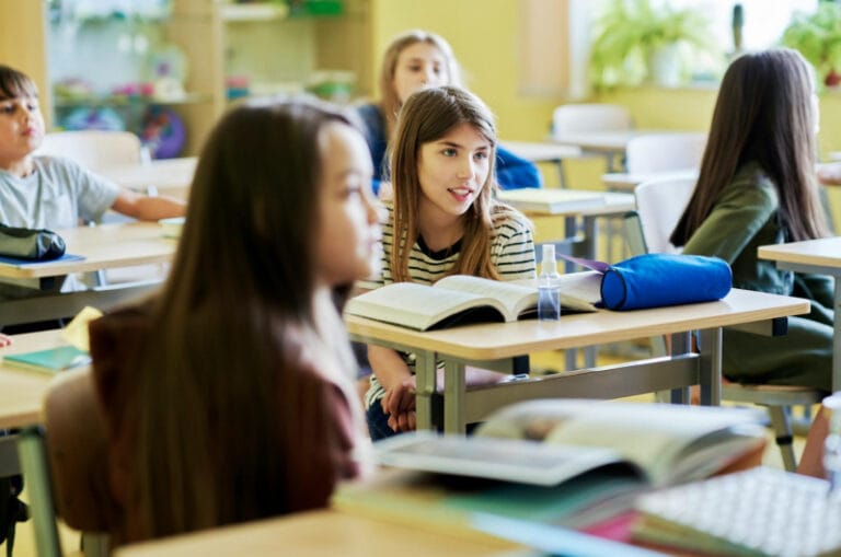 Leerlingen in de klas praten met elkaar tijdens de les over burgerschap