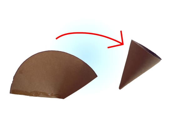 Een halve cirkel van bruin papier wordt opgerold en vastgelijmd tot een hoorntje voor een ijsje van papier