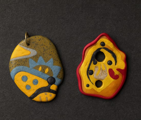 Twee handgemaakte sieraden van polymeerklei geïnspireerd op de GOUD-tentoonstelling in Wereldmuseum Leiden
