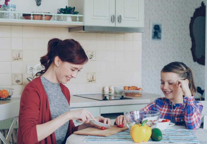 ouder communiceert op een positieve manier met kind aan de keukentafel