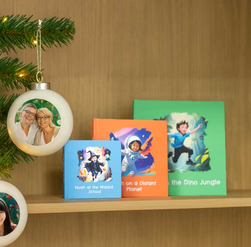 Persoonlijke kinderboekjes van Fotofabriek naast kerstballen met eigen foto aan een kerstboom