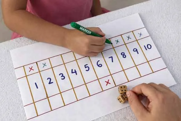 Kind oefent rekenen thuis met shut the box werkblad en dobbelstenen